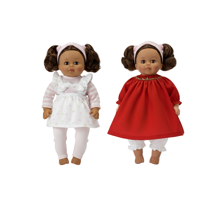 Two multicultural madame alexander dolls, one in a white dress and the other in a Christmas dress