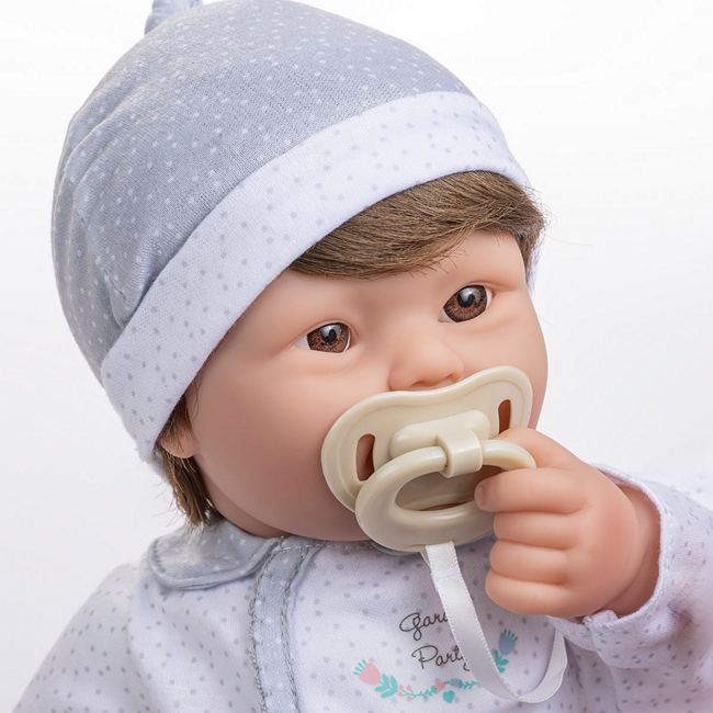 Close up of a down syndrome boy doll with included pacifier in his mouth