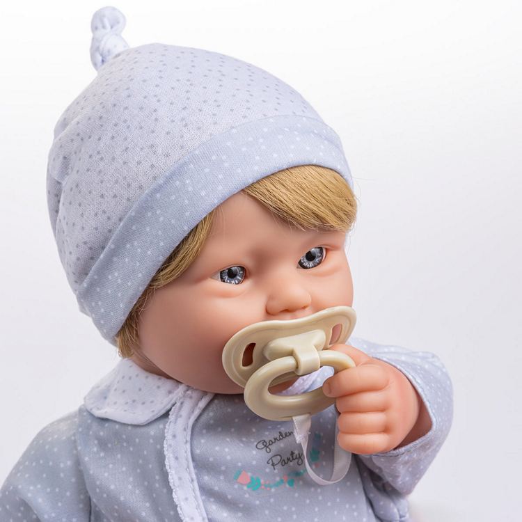 Portrait of a Down Syndrome Boy Baby doll with blonde hair, blue eyes, and a pacifier