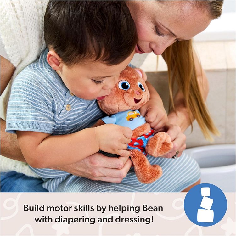 A toddler child dressing a Bean potty training doll with his mother's help
