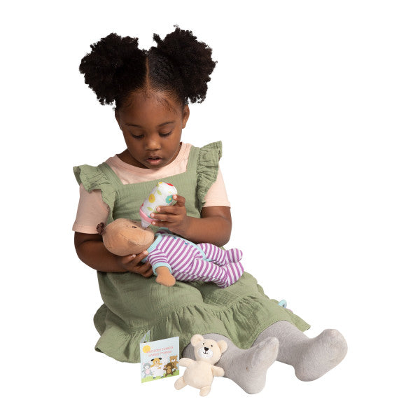 Little girl pretend feeding a baby doll