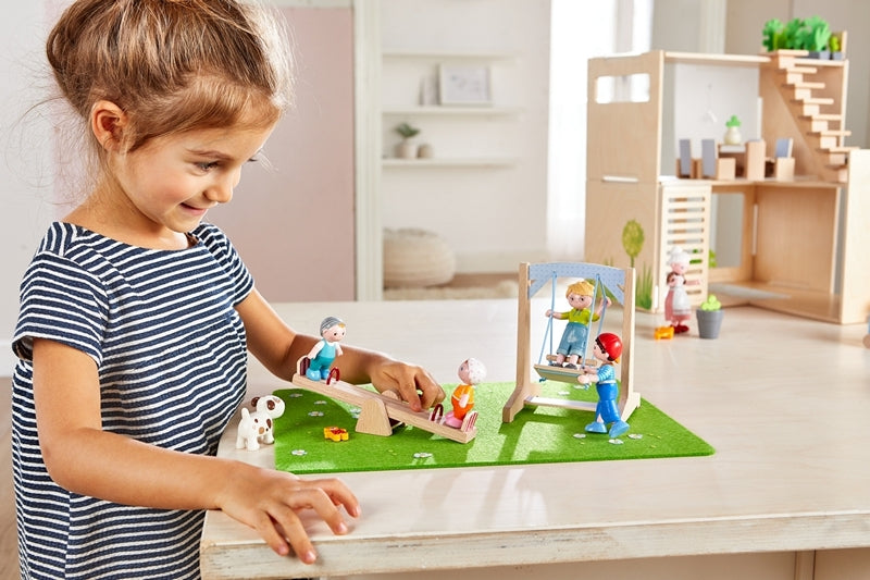 A young girl playing with HABA little friends dollhouse dolls