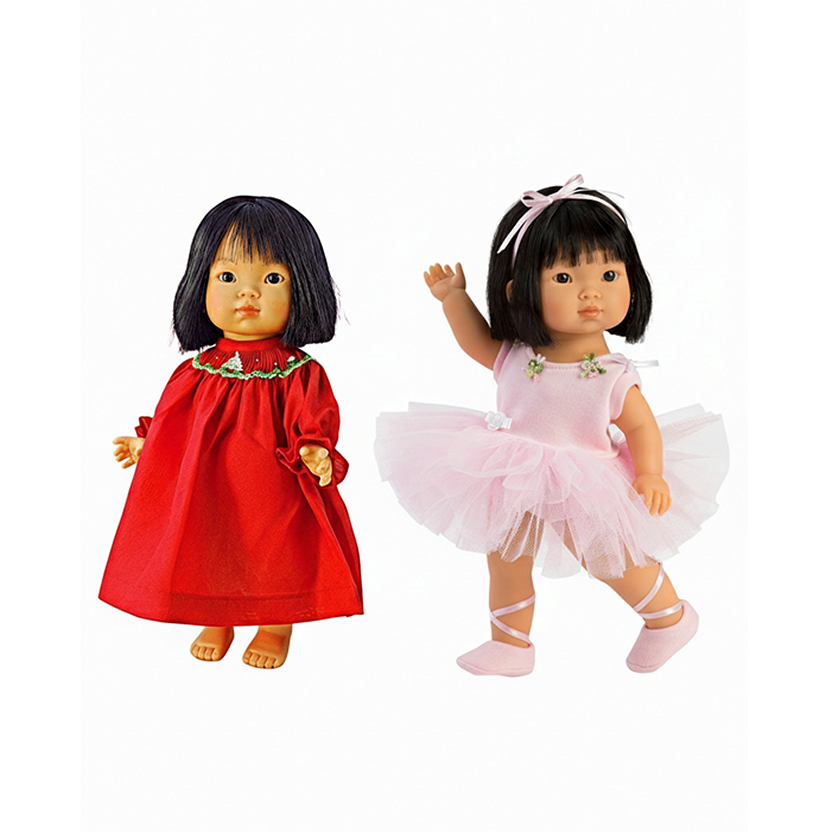 Two dolls, one in a red dress and the other in a pink ballet outfit, on a white background.