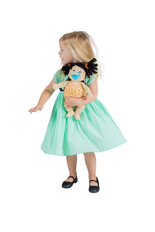 A Young girl holds a Baby Stella Asian Baby Doll