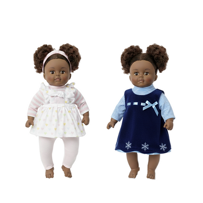 Two Black dolls with natural hair wearing dresses against a white background