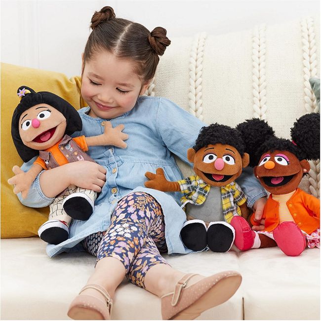 Young girl playing with her Sesame Street Ji-young and Tamir Dolls