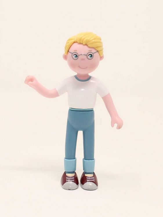 Dollhouse Doll Toy figure of a person with blonde hair, glasses, white shirt, blue pants, and red shoes on a beige background