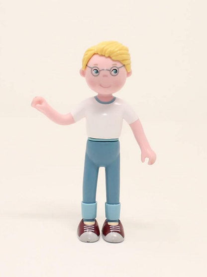 Dollhouse Doll Toy figure of a person with blonde hair, glasses, white shirt, blue pants, and red shoes on a beige background