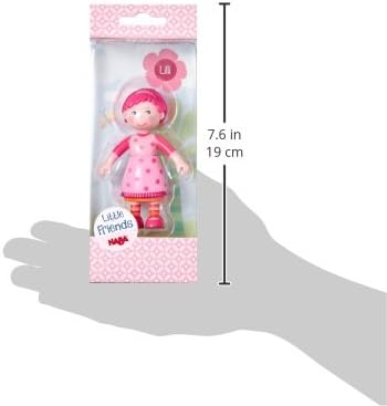 Pink dollhouse doll in packaging with dimensions indicated on a white background with a silhouette of a hand for  scale