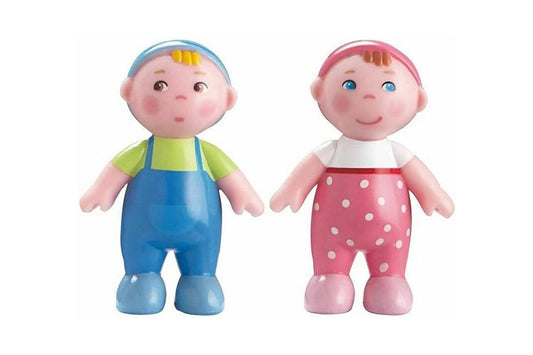 Two baby dollhouse dolls, one in blue overalls and green shirt, the other in pink polka dot pants and white shirt, on a white background.