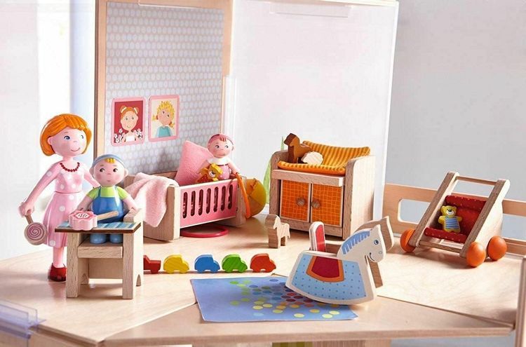 Children's playroom with toys and dollhouse furniture including a rocking horse, dollhouse dolls, and a crib.