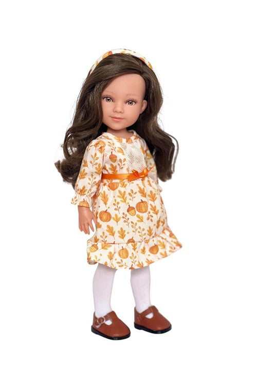 Doll wearing a floral dress with pumpkins on a white background