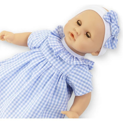 Corolle Calin Milly baby doll lying down with sleeping closed eyes showing blue gingham dress ruffle collar detail and bow headband