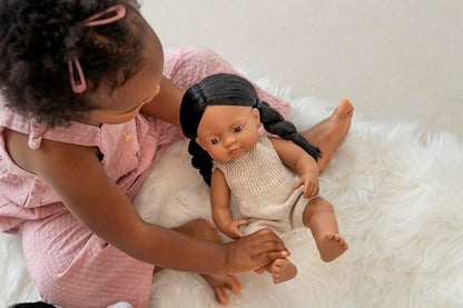 Toddler playing with South Asian and Desi baby doll with warm brown skin and dark hair
