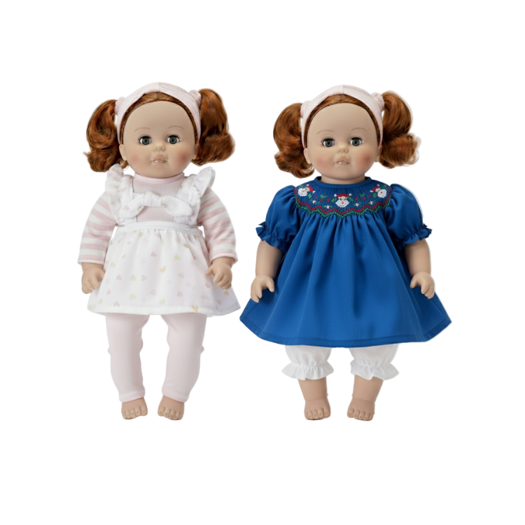 Two dolls with red hair styled in pigtails, one in a white dress and the other in a blue dress with embroidery, on a white background.