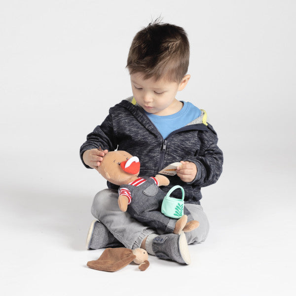A young boy plays with the Baby Stella farmer doll
