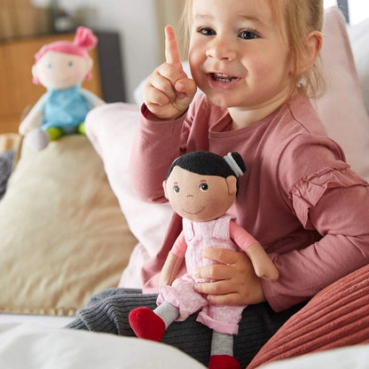 A little girl playing with her Rumbi snug-up doll be HABA