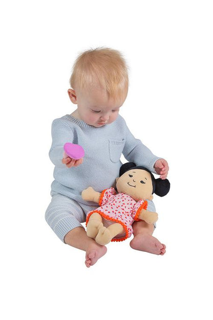 A toddler is fascinated by the magnetic pacifier wee baby stella Asian doll