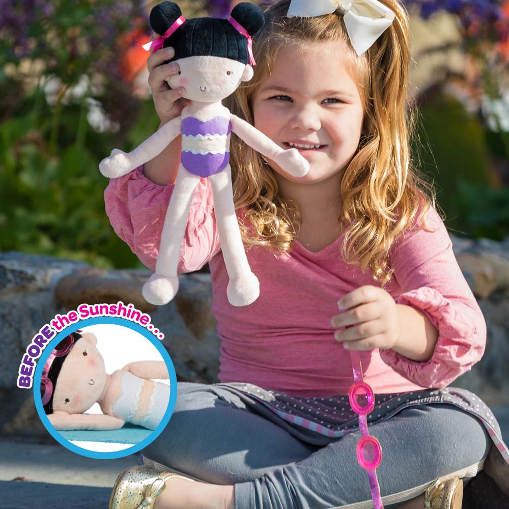 A young girl playing with a color changing plush doll