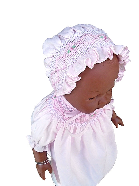 Close up of the beautiful smocking on this black baby doll's bonnet and dress