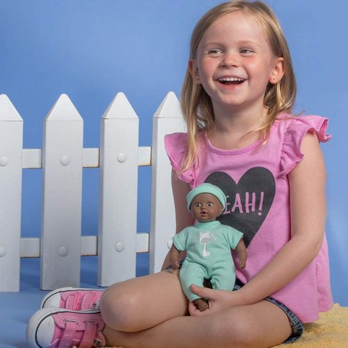 The Black Baby Tots Doll by Adora is a small doll here held by a model  for size comparison