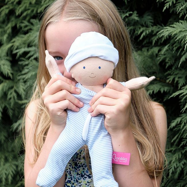 A Young Girl holding up A Bonikka Boy Rag doll