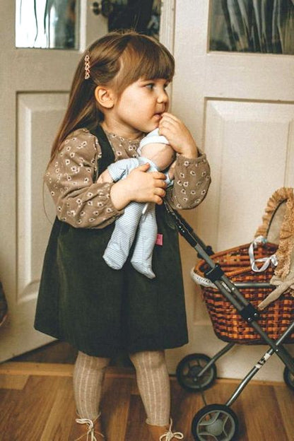 A young girl cuddling a baby boy rag doll