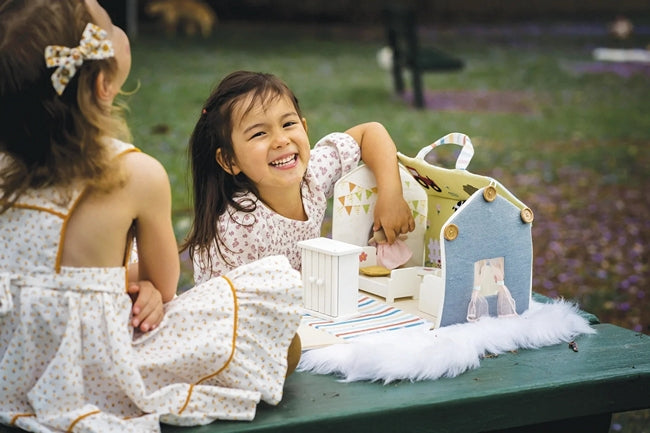 2 little girls playing with Bonikka cloth sided doll's house