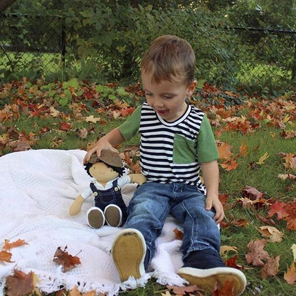 A little boy sitting with his Joe Denim Toddler Boy's Doll