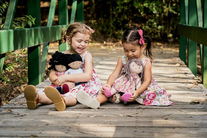 two little girls playing with black rag dolls