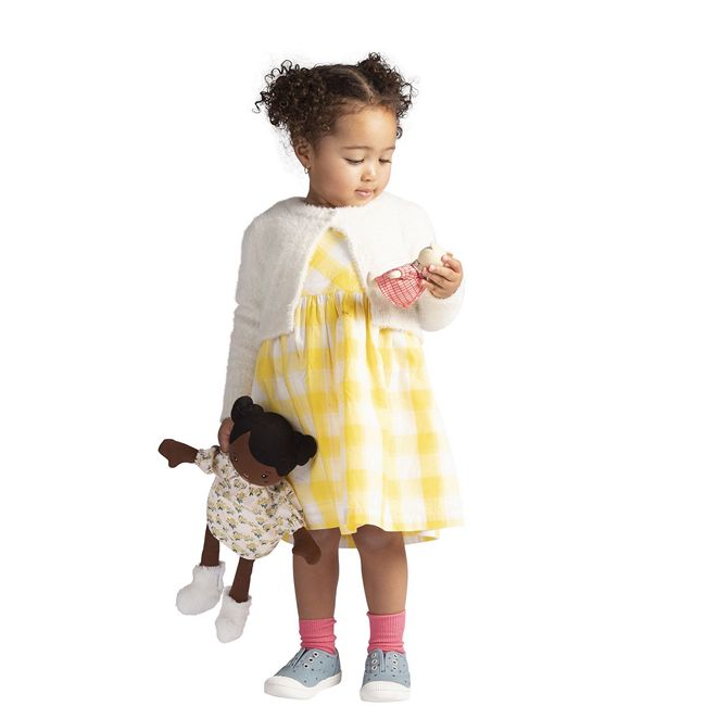 A youngBlack toddler playing with her Black Rag Doll, and her rag doll's teddy bear.