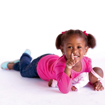 a young girl holding her Black Baby Doll Playtime Princess from Adora