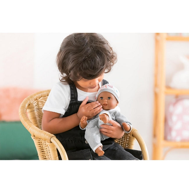 a little black boy playing with his black boy's bby doll Marius from Corolle