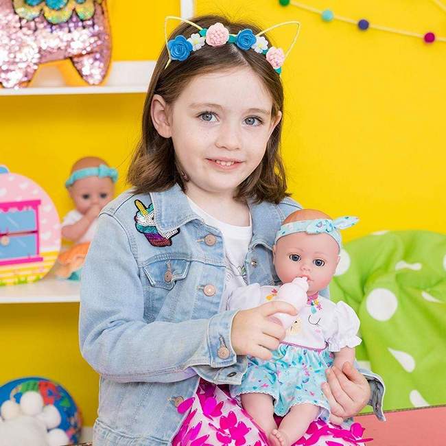 A young girl feeding her adora playtime baby doll with pretend bottle