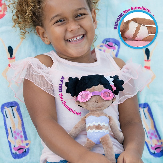 a child holding her color changing doll after it has been in the sun and changed color