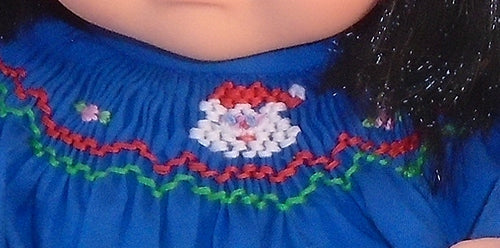 close up of the embroidered santa on a christmas dress for 15 inch dolls