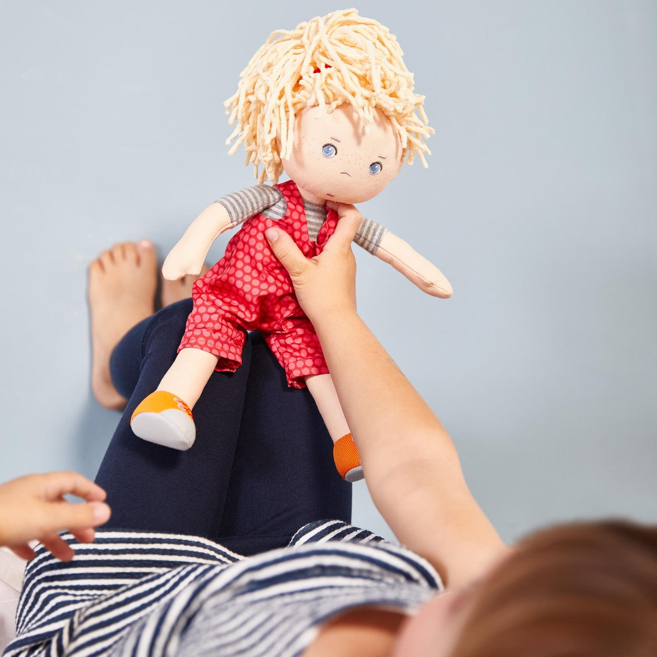 a child playing with her Cassie rag doll by HABA